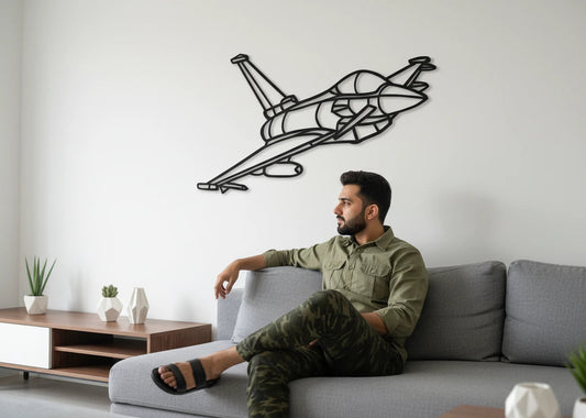 Man sitting on a couch in a living room with a geometric airplane wall art piece. fighter jet wall panel