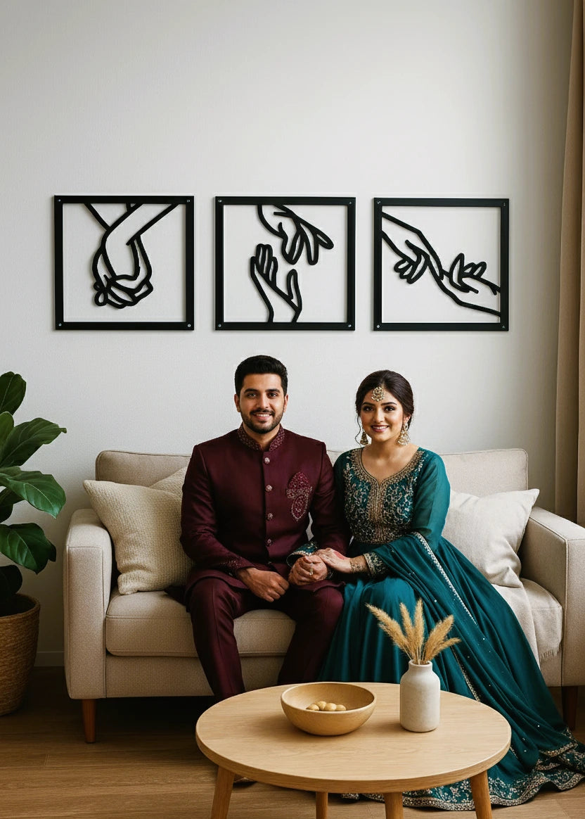 Couple sitting on a couch in a living room with decorative metal wall art and a coffee table.