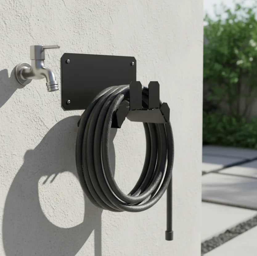 Wall-mounted hose holder with coiled garden hose attached to a concrete wall.