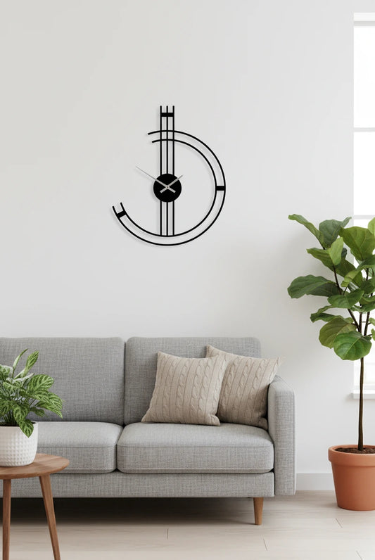 Modern wall clock on a white wall above a gray sofa with decorative pillows.