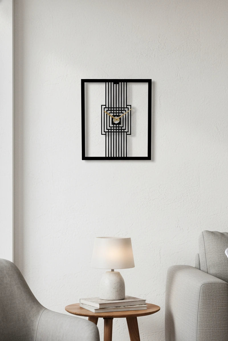 Framed abstract wall clock on a white wall above a side table with a lamp and books.