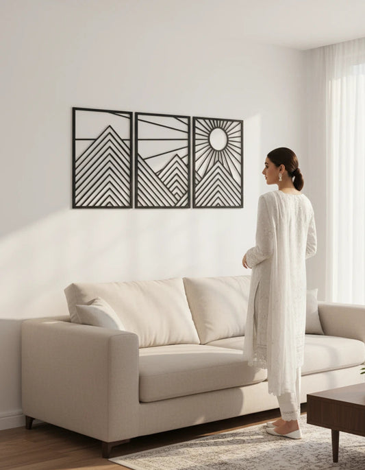 Woman standing in a modern living room with a decorative wall art piece.