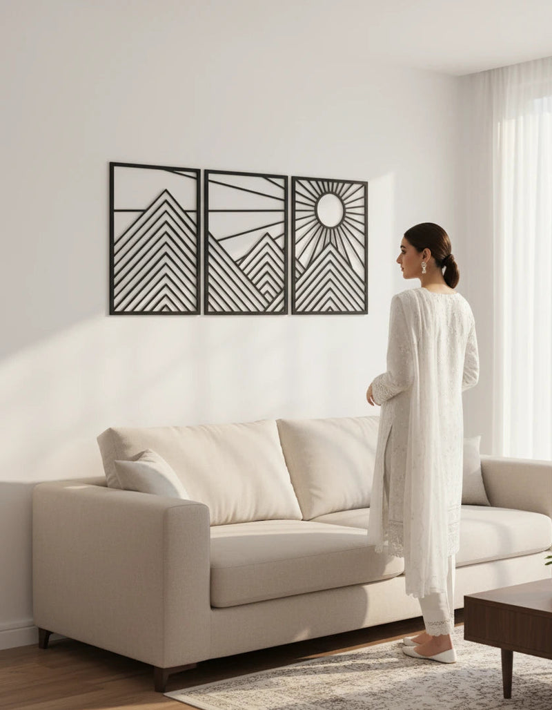 Woman standing in a modern living room with a decorative wall art piece.