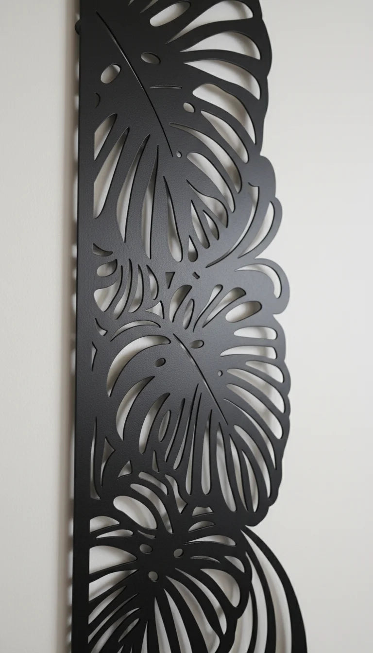 Decorative metal panel with leaf pattern on a white wall