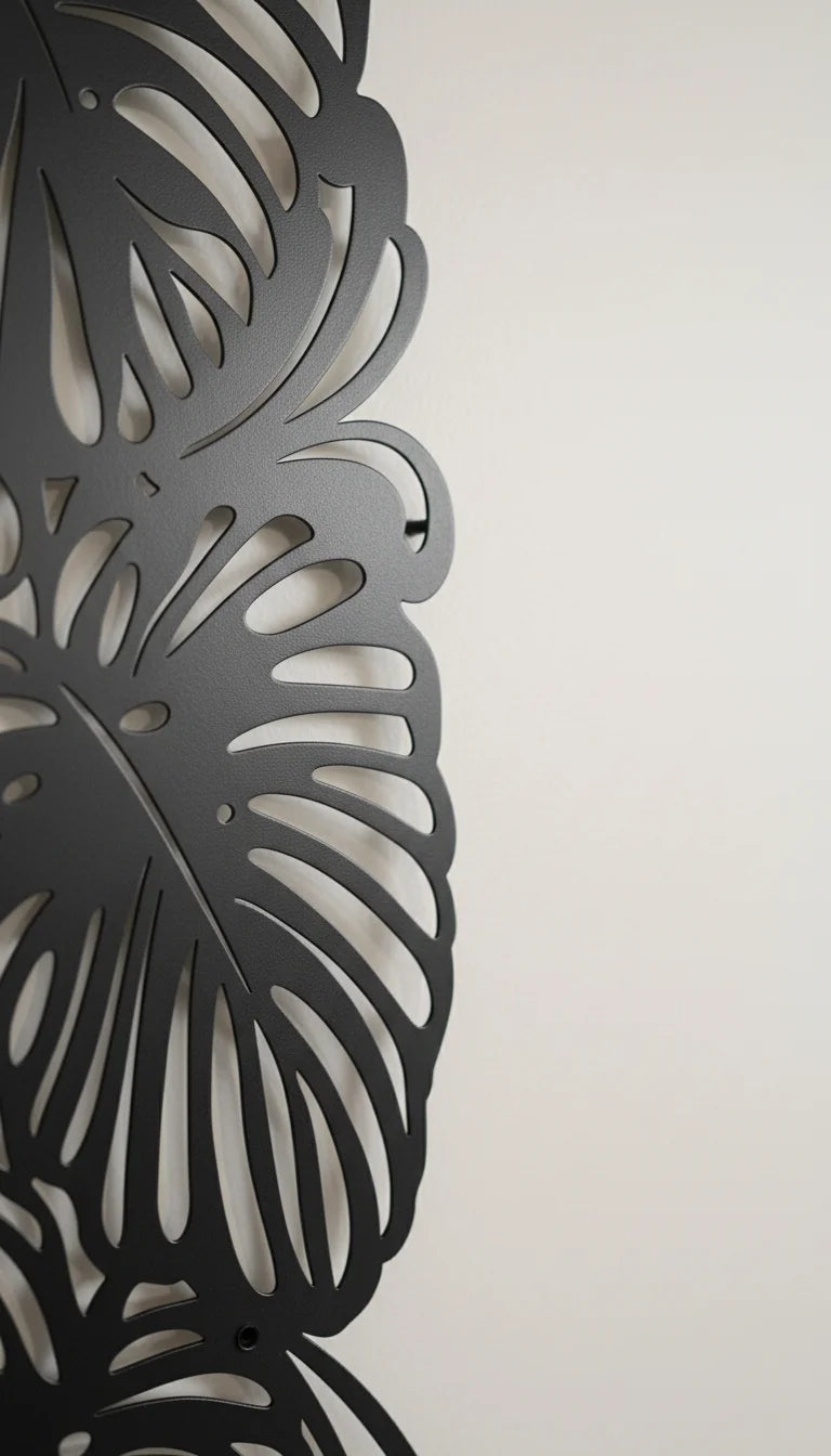 Decorative metal wall art with leaf patterns on a plain background