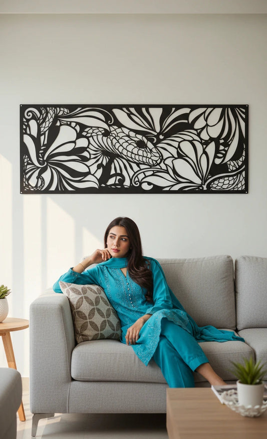 Woman in a blue dress sitting on a gray sofa with decorative wall art in the background. snake metal wall art 