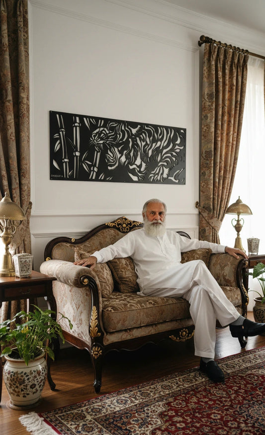 Man sitting on an ornate sofa in a room with decorative elements and artwork. Tiger wall art on the wall.