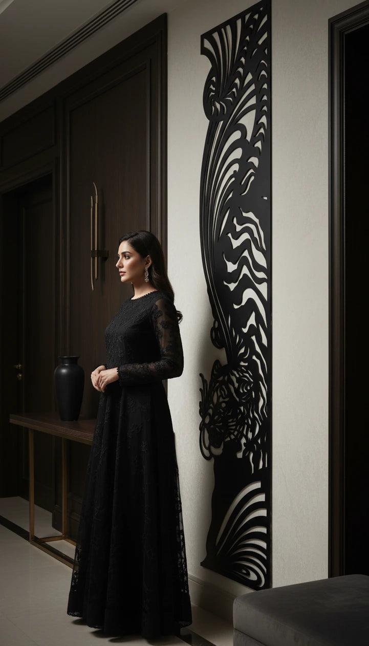 Woman in a black dress standing in a room with decorative wall art.