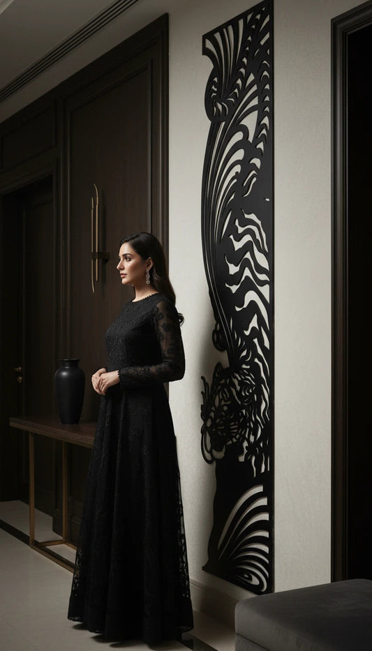 Woman in a black dress standing in a room with decorative wall art.