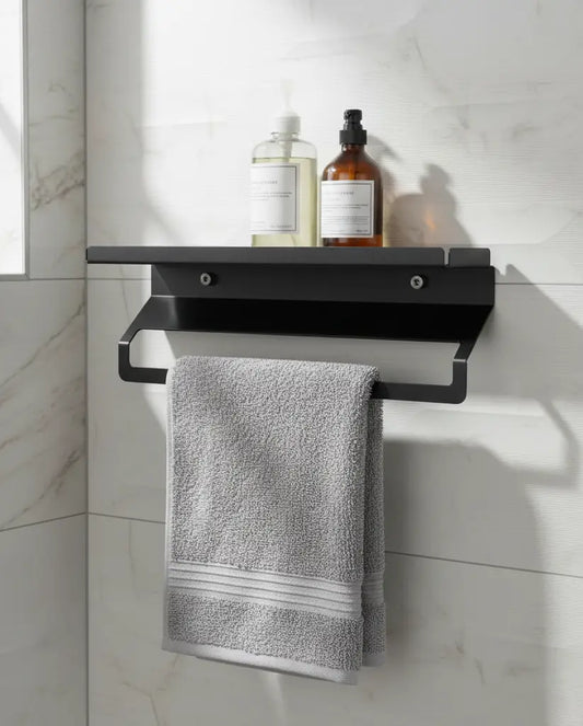 Black towel rack with a gray towel and toiletries on a marble wall.