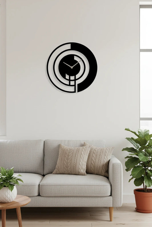 Modern wall clock on a white wall above a gray sofa with decorative pillows.